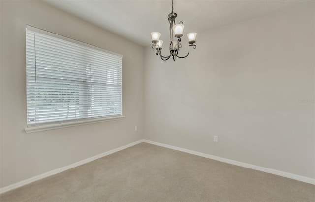 empty room with an inviting chandelier and carpet flooring