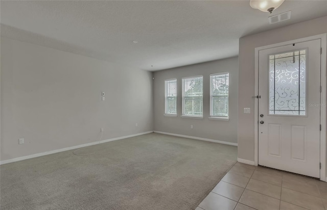 foyer entrance featuring light colored carpet