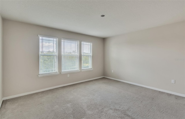 carpeted spare room featuring a textured ceiling