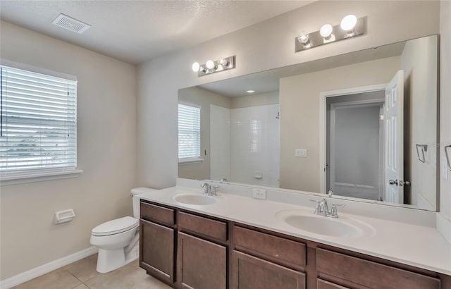 bathroom featuring tile patterned flooring, plenty of natural light, toilet, and vanity