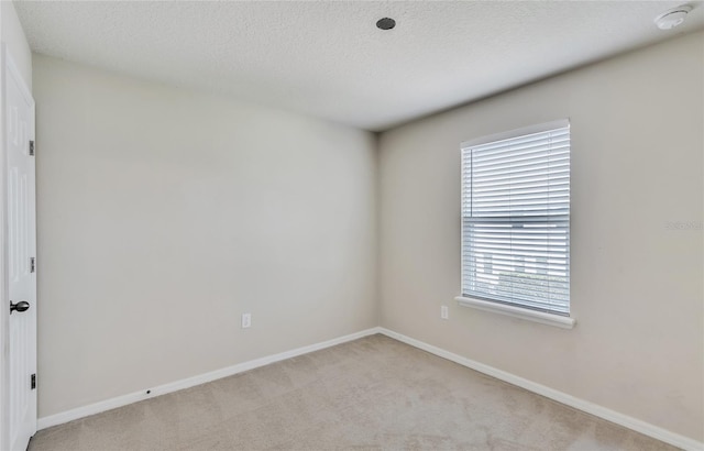 spare room with carpet floors and a textured ceiling