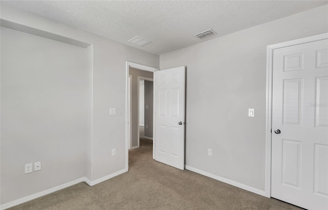 unfurnished bedroom featuring a textured ceiling and carpet flooring