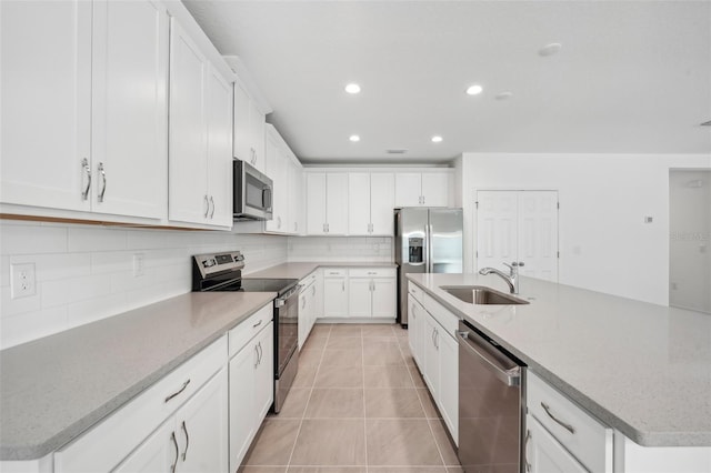 kitchen featuring a kitchen island with sink, appliances with stainless steel finishes, and white cabinets