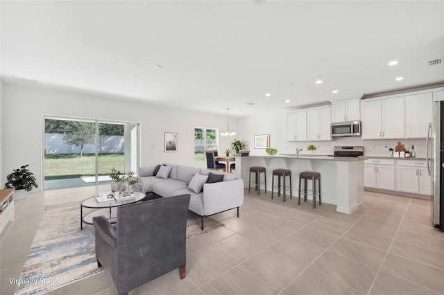 tiled living room featuring an inviting chandelier and sink