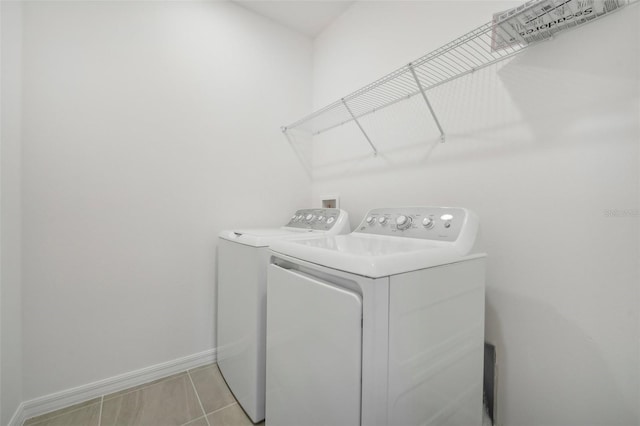 laundry area featuring light tile patterned flooring and washing machine and clothes dryer