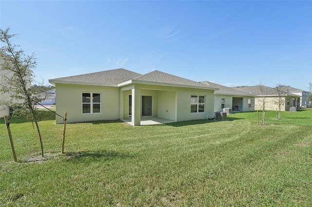 rear view of property with a patio, a yard, and central AC unit