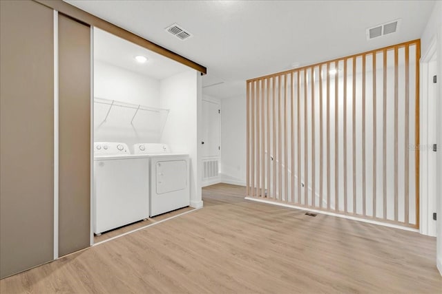 laundry room featuring light wood-type flooring and independent washer and dryer