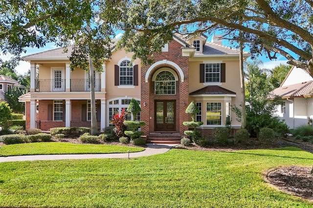 view of front of home featuring a balcony and a front yard