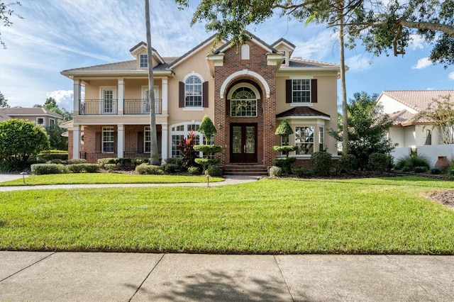 view of front of property with a balcony and a front lawn