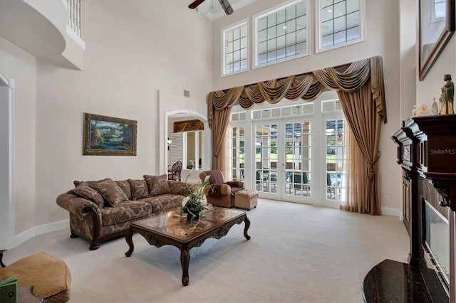 carpeted living room featuring a high ceiling, ceiling fan, and french doors