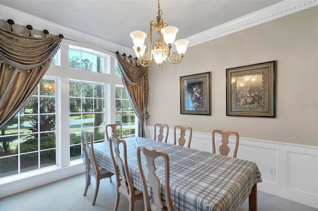 carpeted dining area with a notable chandelier and ornamental molding