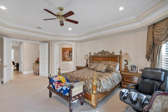 bedroom with ceiling fan, light carpet, a raised ceiling, and crown molding