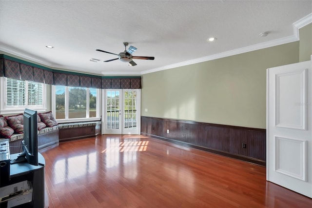 living room featuring hardwood / wood-style floors, ornamental molding, ceiling fan, and a textured ceiling