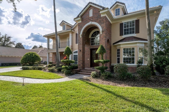 view of front facade with a balcony and a front yard