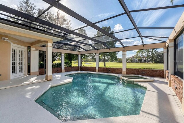 view of swimming pool featuring glass enclosure, french doors, an in ground hot tub, ceiling fan, and a patio