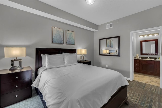 bedroom with sink, tile patterned flooring, and connected bathroom