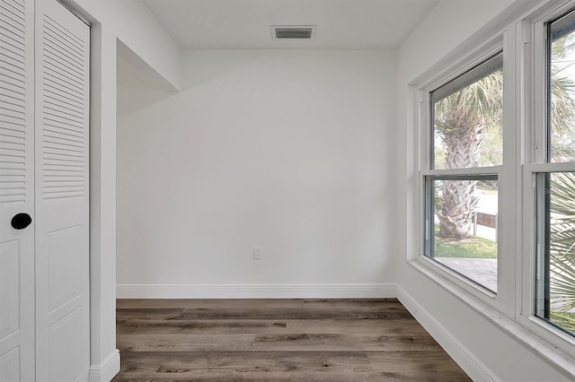 interior space with baseboards, visible vents, and dark wood-type flooring