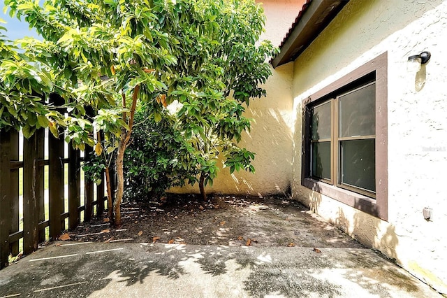 view of property exterior with fence and stucco siding