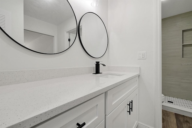 full bathroom featuring toilet, vanity, a shower stall, and wood finished floors