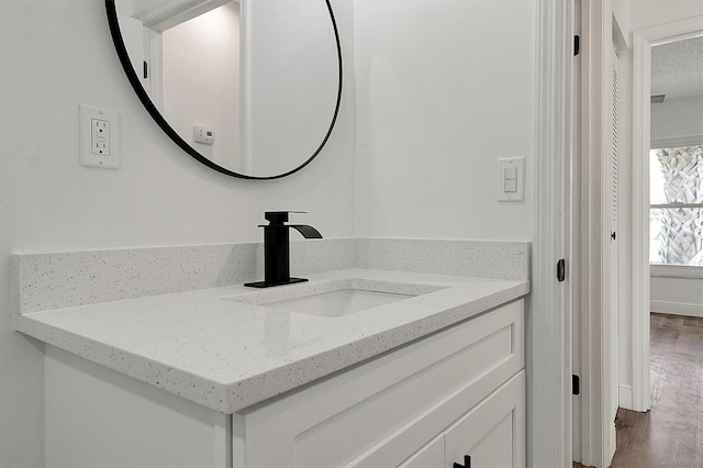 bathroom with vanity, baseboards, and wood finished floors