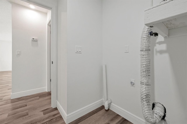 laundry area featuring laundry area, wood finished floors, electric dryer hookup, and baseboards