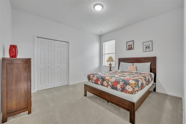 carpeted bedroom with a closet and a textured ceiling