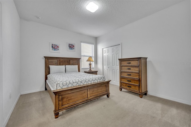 carpeted bedroom with a closet and a textured ceiling