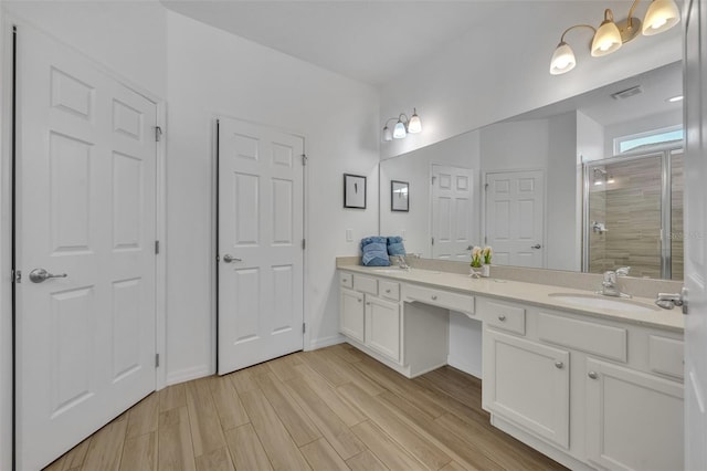 bathroom with walk in shower, vanity, and hardwood / wood-style floors