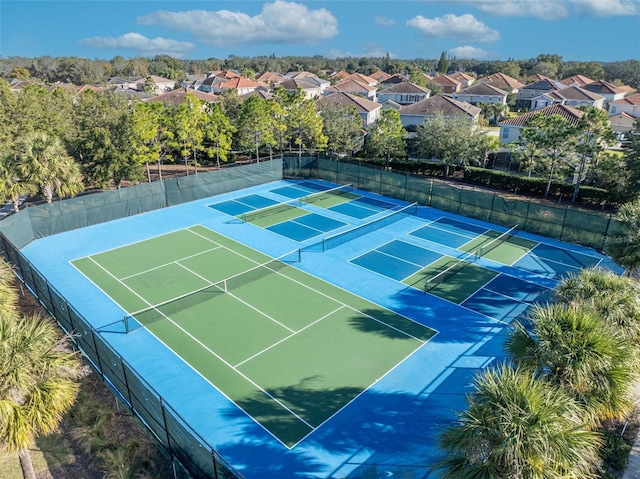 view of tennis court featuring a residential view and fence