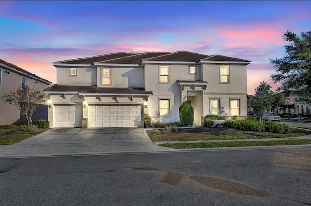 view of front facade featuring concrete driveway, an attached garage, and stucco siding