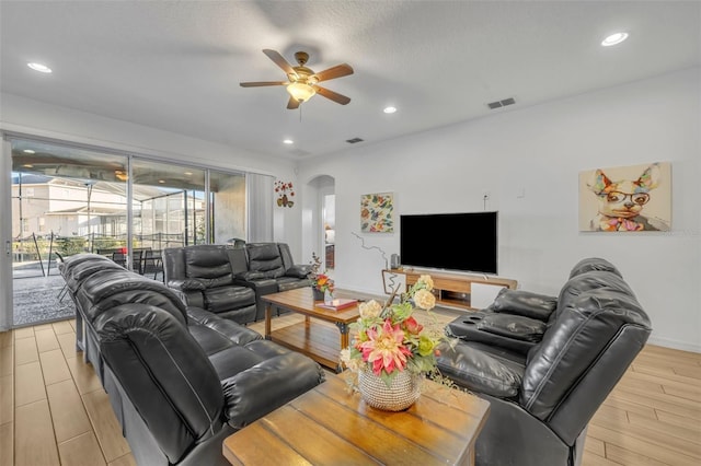 living area with visible vents, arched walkways, ceiling fan, light wood-style flooring, and recessed lighting