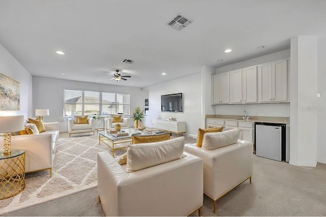 living area featuring indoor wet bar, light colored carpet, visible vents, and recessed lighting