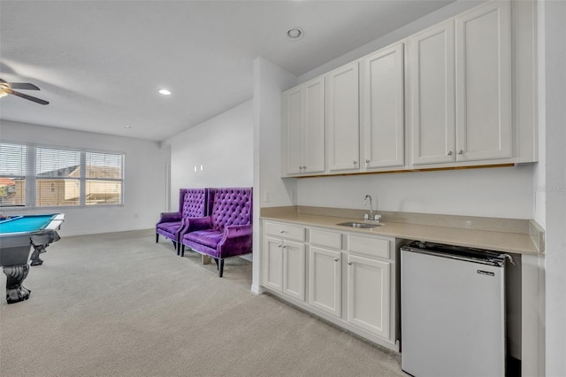 interior space with a sink, white cabinets, open floor plan, light countertops, and freestanding refrigerator