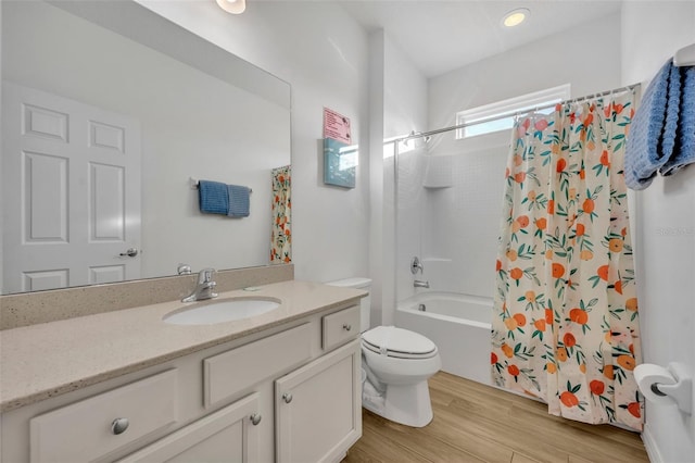 full bathroom with toilet, shower / bath combo with shower curtain, wood finished floors, and vanity