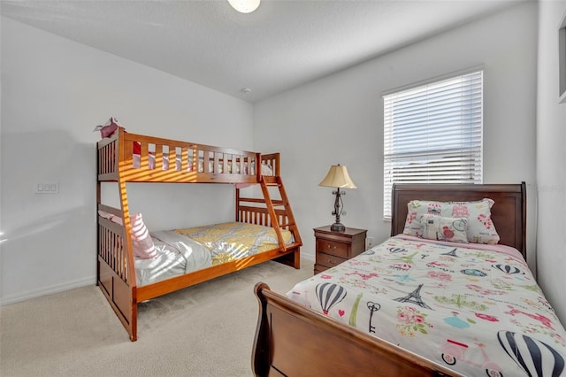 bedroom with light carpet and a textured ceiling