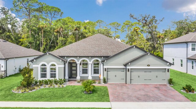 view of front of home with a front yard and a garage