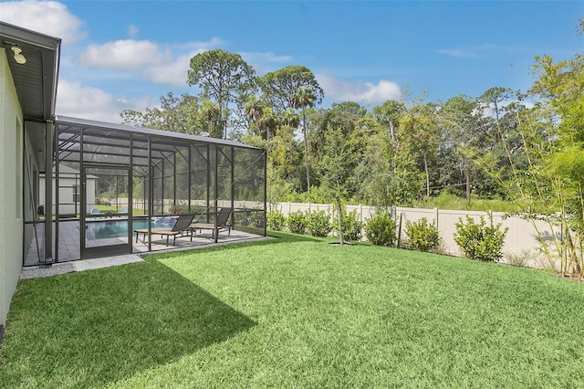 view of yard with a patio area, a fenced in pool, and a lanai