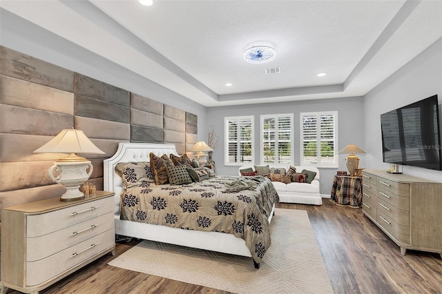 bedroom featuring dark wood-type flooring and a raised ceiling