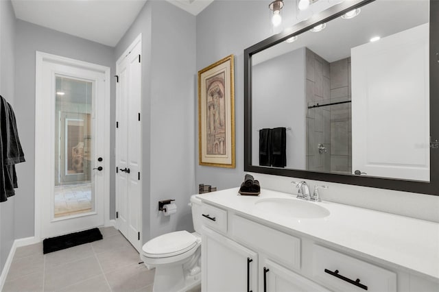 bathroom with vanity, toilet, walk in shower, and tile patterned flooring