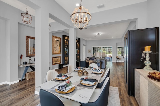 dining area featuring dark wood-type flooring and a notable chandelier