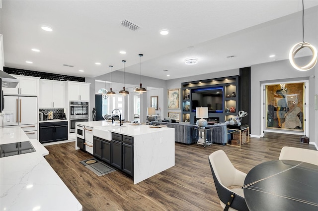 kitchen with dark wood-type flooring, white built in fridge, and stainless steel double oven