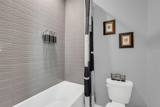 bathroom featuring toilet and tiled shower / bath