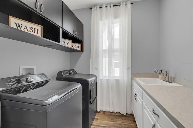 washroom featuring cabinets, dark hardwood / wood-style flooring, washer and clothes dryer, and sink