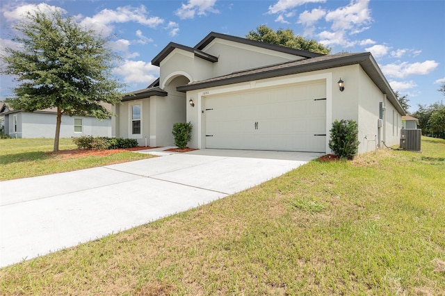 view of front of home featuring central air condition unit, a garage, and a front yard