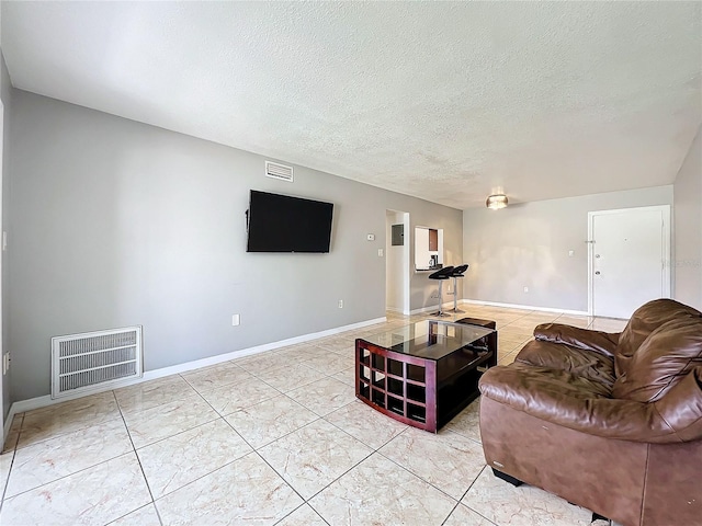 tiled living room featuring a textured ceiling