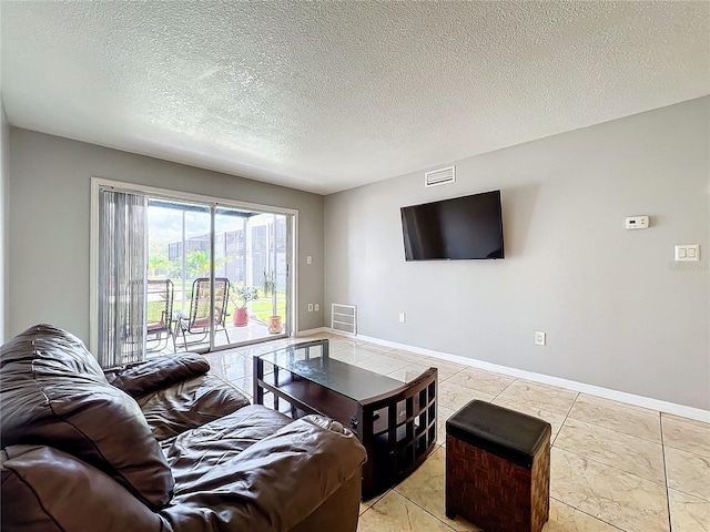 living room featuring light tile patterned floors and a textured ceiling