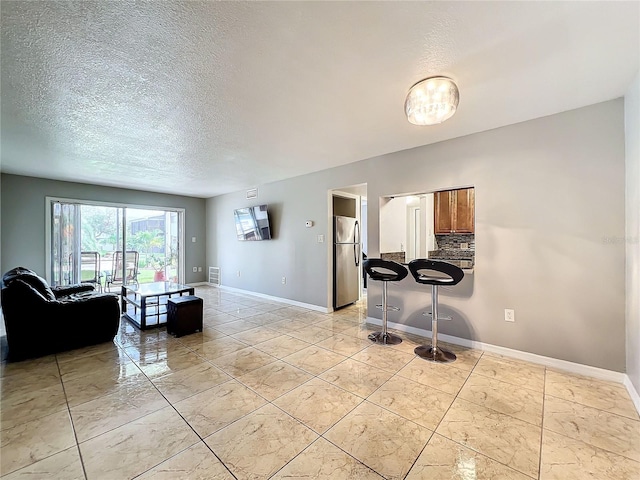 interior space featuring a textured ceiling and light tile patterned floors