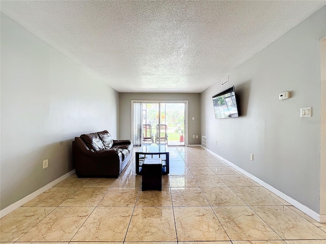 living room featuring a textured ceiling and light tile patterned flooring