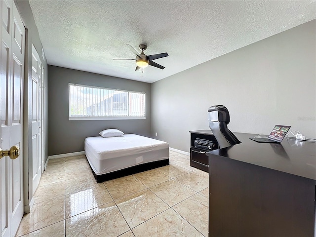 bedroom with ceiling fan, a textured ceiling, and light tile patterned floors