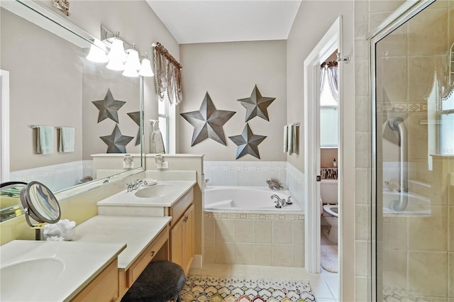 full bathroom featuring toilet, vanity, tile patterned flooring, and shower with separate bathtub